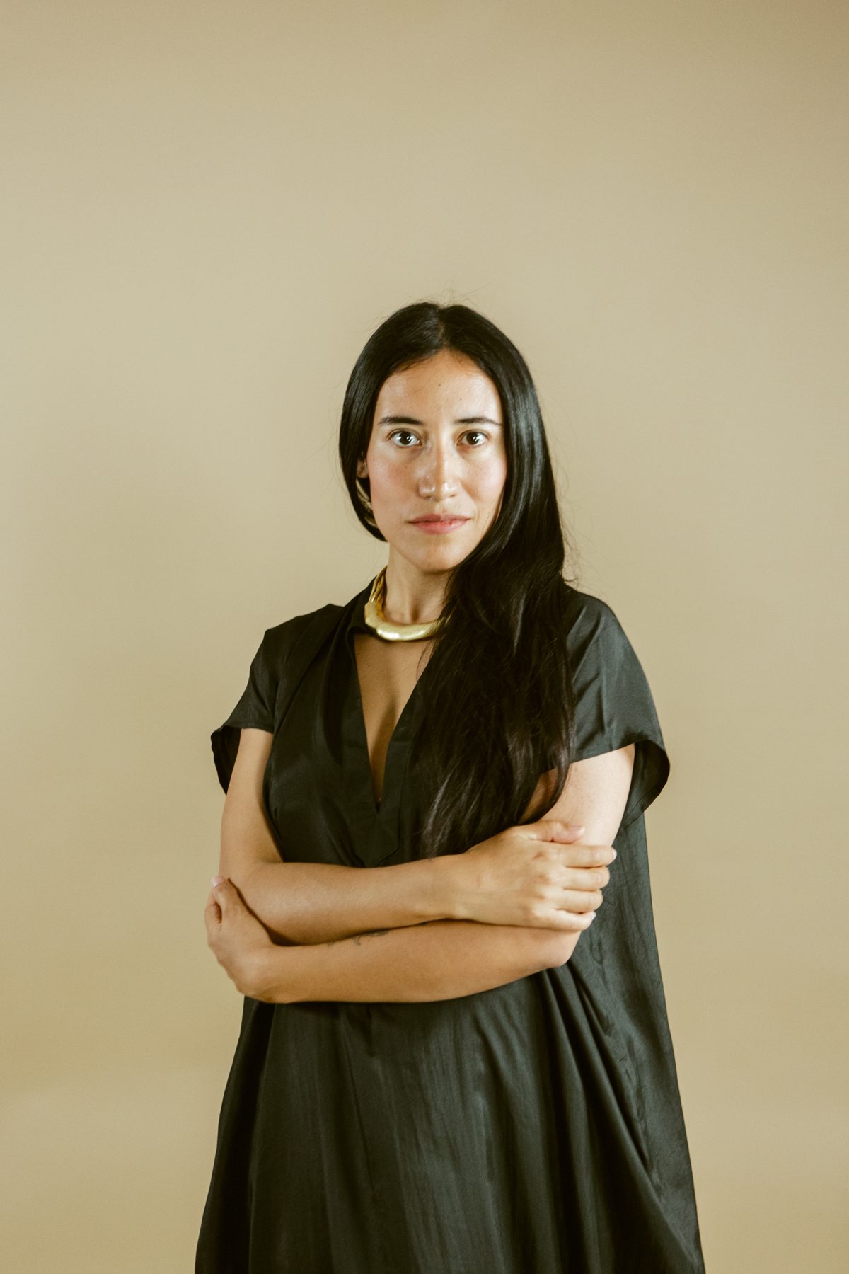 Andrea, founder of Nuu Atelier, in a black dress in the tan studio